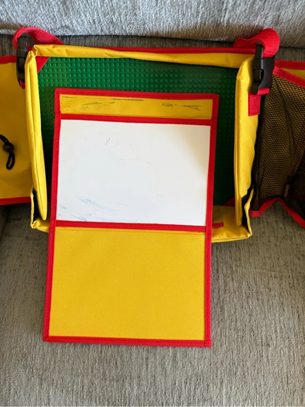 Kids travel activity organizer features a fold-out flat play surface. See detail